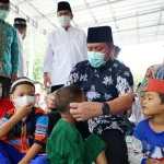 Herman Deru turut membagikan masker secara langsung kepada para jemaah, termasuk memasangkannya kepada anak-anak yang hadir di masjid. (MUSINEWS.ID/HAIRUDIN)