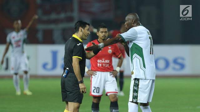 Pemain PS TNI, Franklin Anzite Touadere (kanan), melakukan protes kepada wasit, Alireza Faghani, saat melawan Persija pada lanjutan Liga 1 Indonesia di Stadion Patriot Candrabhaga, Bekasi, Sabtu (30/9). Persija menang 4-1. (Liputan6.com/Helmi Fithriansyah)