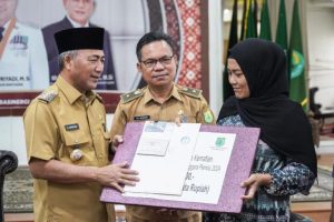 Pj. Bupati Kabupaten Musi Banyuasin (Muba), H. Apriyadi Mahmud, didampingi oleh Sekretaris Komisi Pemilihan Umum (KPU) Muba, Dedi Irawan, menyerahkan langsung santunan kematian kepada ahli waris Petugas Kelompok Penyelenggara Pemututan Suara (KPPS) Pemilihan Umum (Pemilu) tahun 2024 yang meninggal dunia saat menjalankan tugasnnya. (foto : Dinkominfo Sumsel)