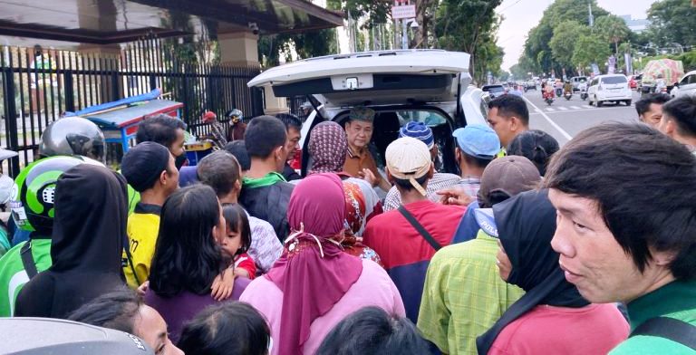 Anggota DPRD Provinsi Sumatera Selatan, Chairul S. Matdiah, membagikan nasi bungkus kepada pengendara dan masyarakat yang melintas di Jalan POM IX, Palembang, hari Minggu tanggal 31 Maret 2024.
