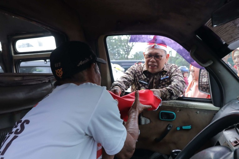 Pj Walikota A Damenta bersama Forum Komunikasi Pimpinan Daerah (Forkompimda) membagikan ribuan bendera merah putih kepada masyarakat dan pengendara yang melintas di Simpang 5 DPRD Sumatera Selatan (Sumsel), Kamis (15/8/2024) pagi.