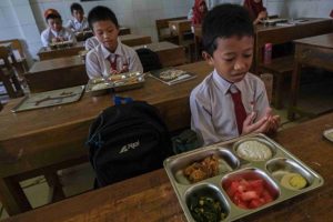 Sejumlah siswa Sekolah Dasar berdoa sebelum menyantap makanan bergizi gratis di SDN 10 Kendari, Kendari, Sulawesi Tenggara, Senin (6/1/2025). Badan Gizi Nasional (BGN) melaksanakan program makan bergizi gratis perdana di sejumlah sekolah di Kota Kendari guna mematangkan ketepatan waktu distribusi serta kecukupan kandungan gizinya. ANTARA FOTO/Andry Denisah/nz
