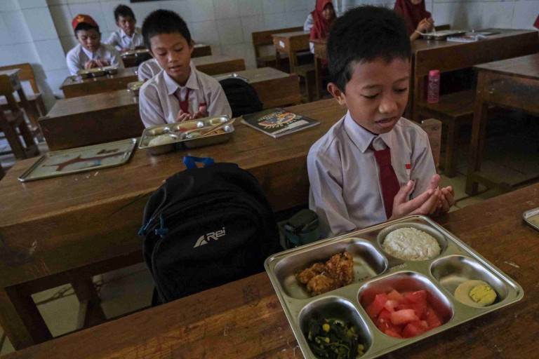 Sejumlah siswa Sekolah Dasar berdoa sebelum menyantap makanan bergizi gratis di SDN 10 Kendari, Kendari, Sulawesi Tenggara, Senin (6/1/2025). Badan Gizi Nasional (BGN) melaksanakan program makan bergizi gratis perdana di sejumlah sekolah di Kota Kendari guna mematangkan ketepatan waktu distribusi serta kecukupan kandungan gizinya. ANTARA FOTO/Andry Denisah/nz