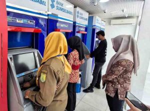 Suasana di sekitar ATM dipenuhi dengan tawa dan kegembiraan, menciptakan momen yang penuh harapan bagi para TKK.