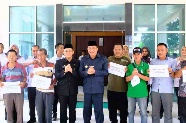 Bupati Musi Banyuasin H M Toha Tohet SH saat menyerahkan bantuan alat pasca panen berupa bak pembekuan getah karet kepada kelompok petani yang tergabung dalam Unit Pengolahan dan Pemasaran Bokar (UPPB), di halaman Kantor Dinas Perkebunan Muba, Rabu (29/10/2025).