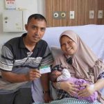 Desi Damayanti (40), warga kecamatan Sako, duduk tenang bercerita tentang pengalamannya sebagai peserta Program Jaminan Kesehatan Nasional (JKN).