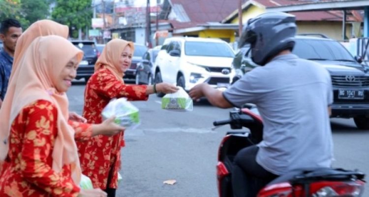 Pegawai di lingkungan Dinas Kominfo Kota Palembang melakukan pembagian menu berbuka puasa kepada masyarakat yang melintas di depan kantor. (MUSINEWS.ID/HAIRUDIN)