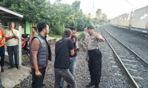 Petugas kepolisian melakukan evakuasi korban wanita yang tertabrak kereta api di Prabumulih.