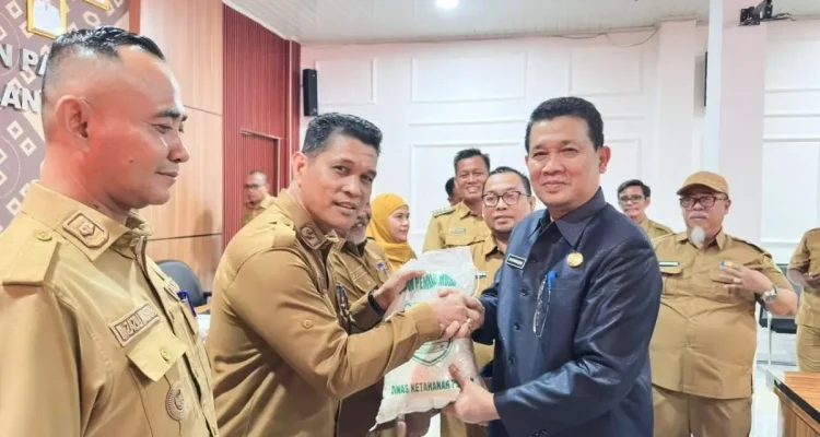 Sekda Muba Syafaruddin menyerahkan Bantuan Cadangan Pangan Muba kepada desa penerima secara simbolis.